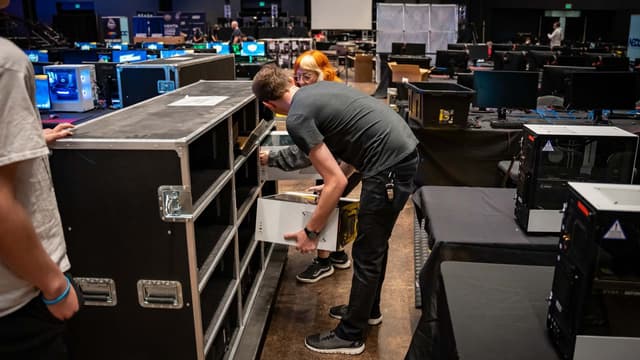 Crew member unpacking a PC road case on an event floor