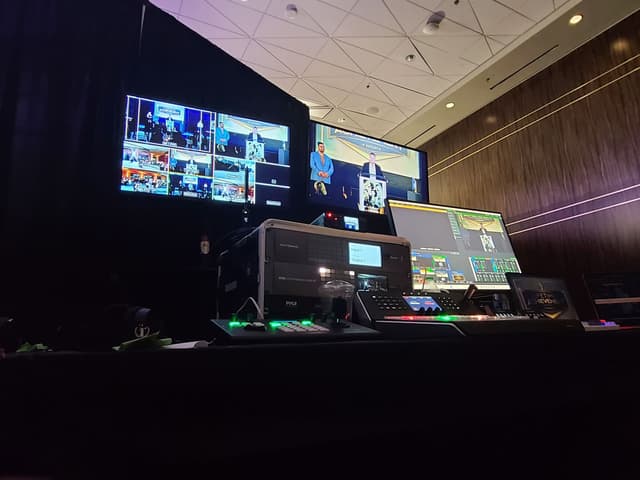 Broadcast control desk with multi-camera monitors at a live event